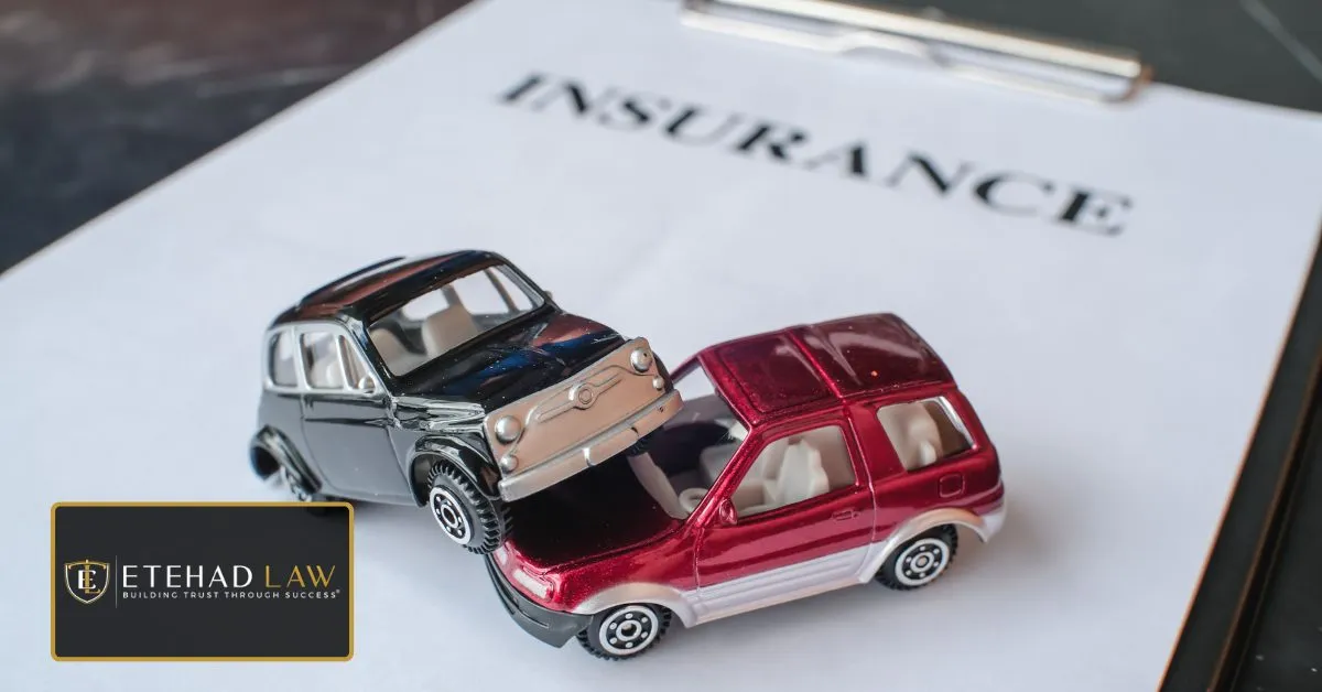 Two model cars involved in a collision on top of an insurance document, representing a car accident insurance claim.