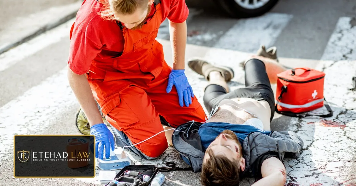 Paramedic treating an injured man lying on the road at the scene of a collision