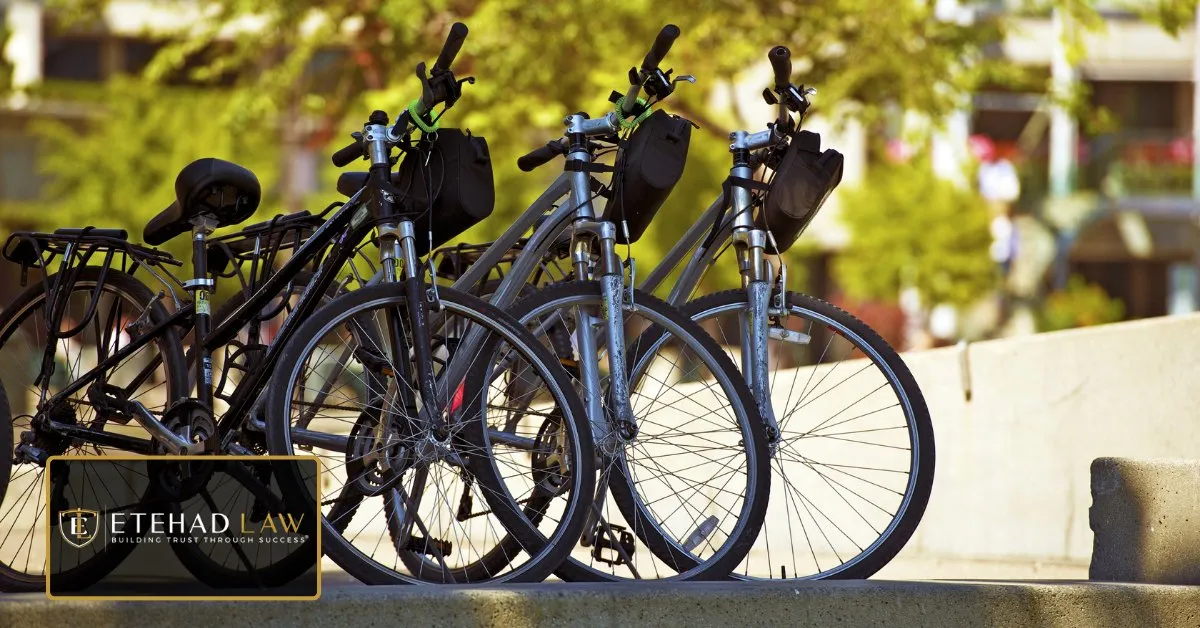 A row of bicycles and electric bikes parked along a sunlit city street