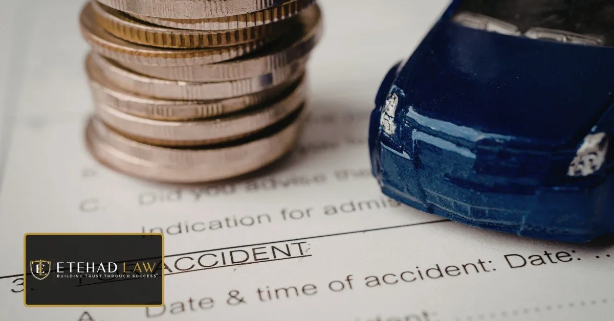 Stacked coins beside a toy car resting on a car accident claim form, representing how a settlement amount is worked out