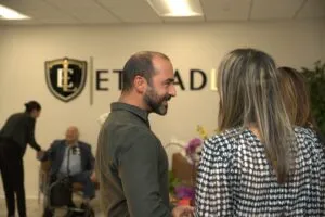 Guests talking beside the Etehad Law crest in the new office