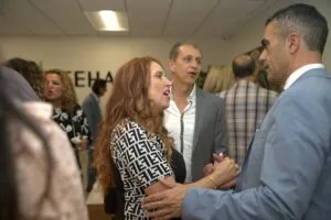 Guests greeting one another in the open-plan office during the party