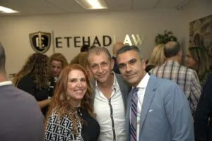 Three guests smiling together at the grand opening reception