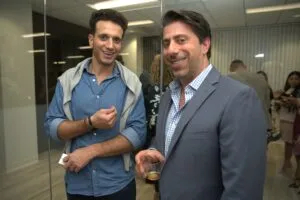 Two guests talking and laughing near the office glass partition
