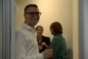 A guest in conversation in a doorway during the opening party