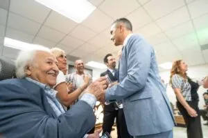 Two guests greeting each other warmly at the grand opening reception