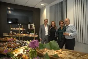 Guests standing beside the catering table at the office opening
