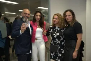 Four guests posing with drinks at the reception