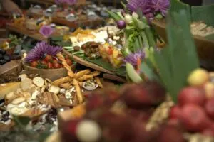 Close-up of a grazing table of cheeses, fruit and flowers at the event