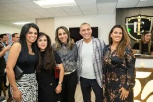 A group of guests posing together beneath the Etehad Law crest at the opening