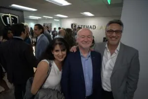 Three guests posing together in the crowded reception