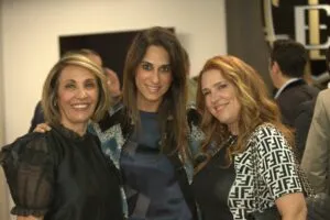 Three guests posing together at the grand opening