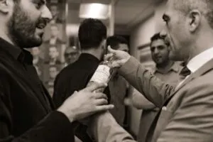 Black-and-white photo of guests shaking hands at the office opening reception