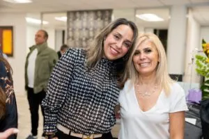 Two guests posing together at the grand opening reception