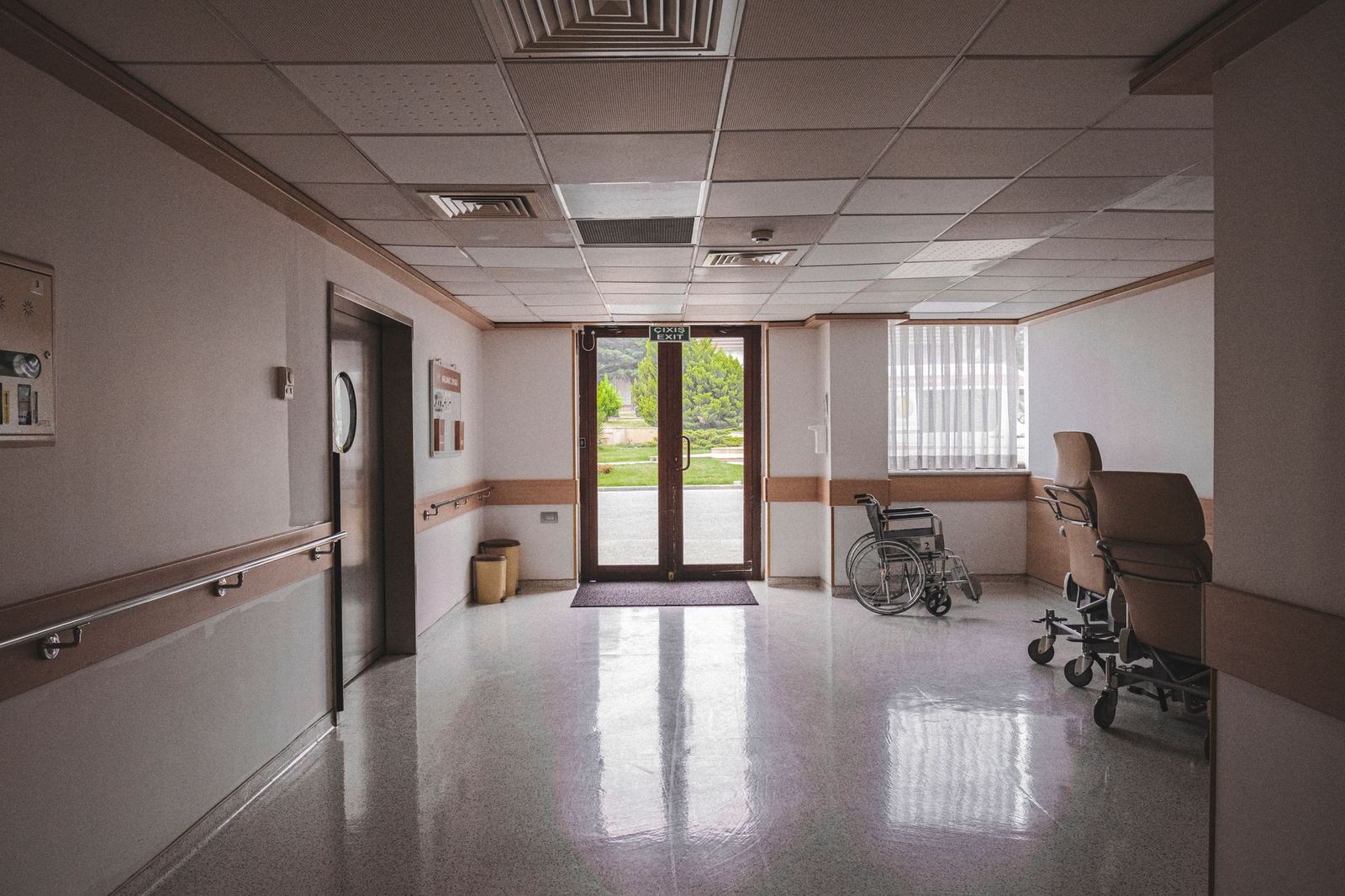 Empty wheelchairs beside the exit in a quiet nursing home hallway