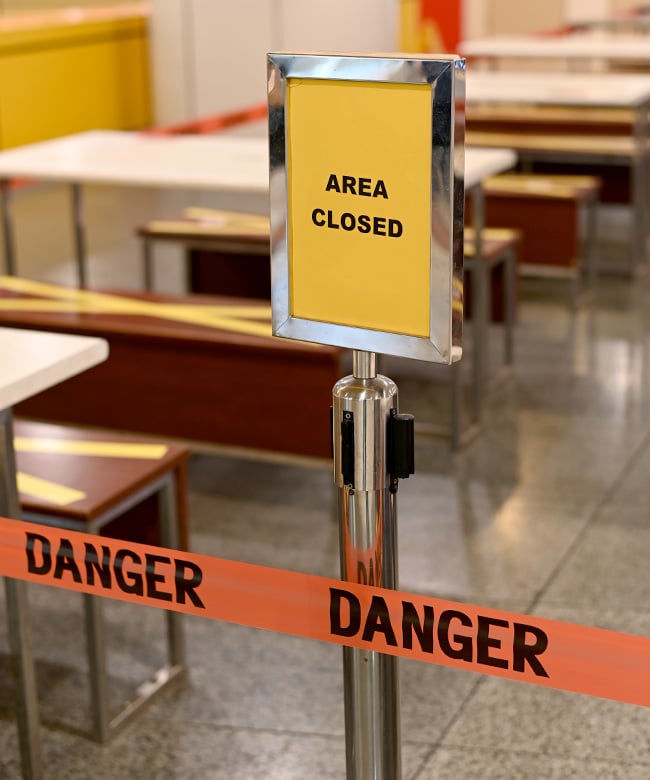 Danger tape and an ‘Area Closed’ barrier cordoning off a hazardous area on a commercial property