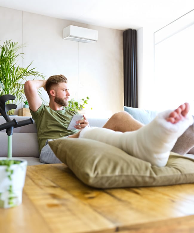 Injured man with a leg cast recovering at home after a serious accident
